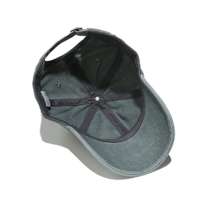 Detail of cotton baseball cap interior showing six-panel stitching and metal buckle