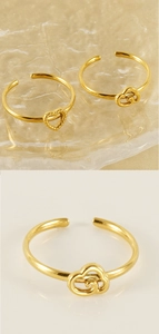 Macro view of adjustable gold-finish ring featuring heart and clover interlaced details