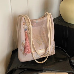 Pink silk fabric tote bag featuring elegant floral embroidery and a beaded tassel charm