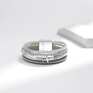 Detail of multilayer bracelet featuring woven leather, gray beads and crystal chains
