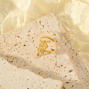 Detail view of a gold snake ring with realistic wave texture and black stone eyes