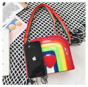 Detailed top view of rainbow heart crossbody bag with wide strap next to a mobile phone
