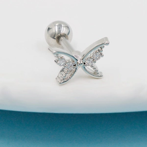 Macro shot of silver butterfly ear stud with zircon inlay and screw ball back closure