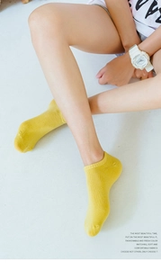 Close-up of yellow low-cut cotton ankle socks featuring a ribbed cuff and knitted texture