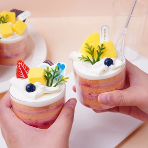Realistic fruit mousse cake cup with mango, blueberries and cream for home decoration