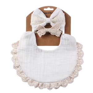 Close-up of baby bib set with cotton lace headband on cardboard packaging