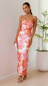 Détail des imprimés floraux roses et oranges sur une robe midi blanche sans manches