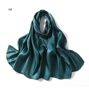 Detailed view of the dark emerald green satin scarf with smooth texture and soft drapes