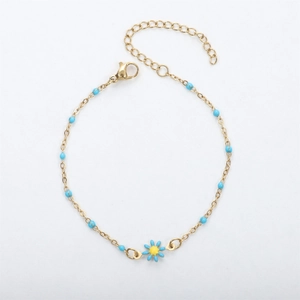 Detail of 18K gold daisy bracelet featuring blue enamel petals and bead chain accents