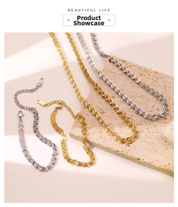 Detailed close-up of gold and silver stainless steel chain necklace with lobster clasp
