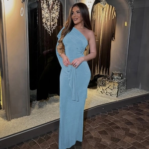 Detail view of a blue one-shoulder slim-fit maxi dress worn by a model in a boutique