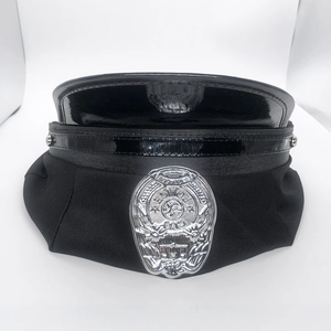 Close-up of a silver metal police badge with engraved details on a black officer cap