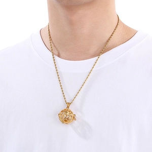 Gold hollow globe pendant necklace with twisted chain shown on a model neck