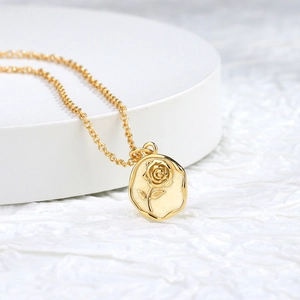 Elegant gold rose embossed oval pendant necklace with a fine chain in minimalist style