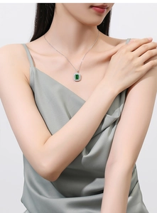 Macro view showing detail of emerald green square cut stone set in silver necklace