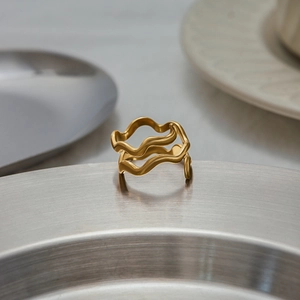 Detailed close-up of 18K gold-plated wavy ring with multi-layered curved metal textures