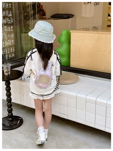 Detail view of the lavender floral kids sling bag featuring clear quicksand PVC window
