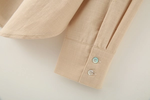 Close-up of linen shirt cuffs with pearlescent buttons and detailed fabric texture