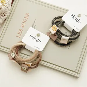 Close-up of velvet animal print hair scrunchies with cute tiger charm and logo tag