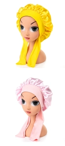 Detail of pink and yellow satin baby sleep caps with adjustable long ribbon ties