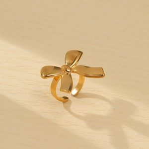 Detail of a vintage golden bow ring with a textured metallic finish and 3D design