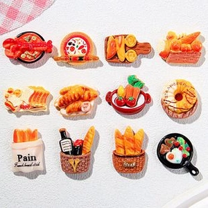 Flat lay of twelve resin miniature food charms including pizza, lobster and bread