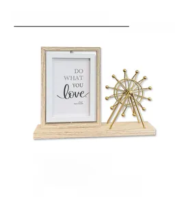 Close-up of a rotating wooden 4x6 picture frame with a gold Ferris wheel design on a base