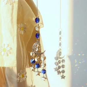 Detail of crystal suncatcher with moon frame reflecting colorful rainbow prisms