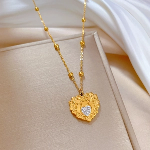 Detail of a hollow gold heart necklace with zircon inlay on a luxury display box