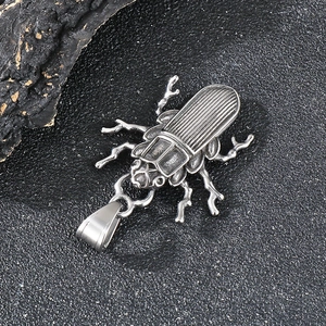Macro detail of a punk-style beetle pendant with vintage aged stainless steel texture