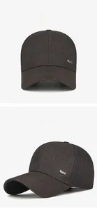Detail of dark brown baseball cap showing the side silver metal Sport logo and twill fabric