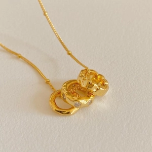 Detail of 925 silver necklace with interlocking gold rings and zircon pendant close-up