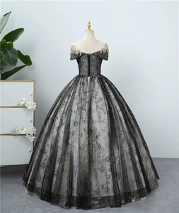 Elegantes Abendballkleid in Schwarz und Gold mit Stickerei und Schnürung am Rücken.