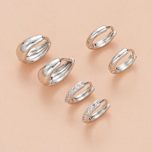 Three-piece silver huggie earring set with polished hoops and zircon drop accents