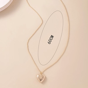 Detail of 60cm golden necklace with heart locket featuring an embossed pet paw print design
