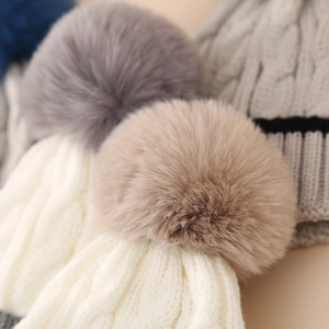 Winter knit beanie for baby boys with cable knit texture and faux fur pom pom