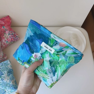 Close-up of a floral fabric makeup bag featuring vibrant blue and green liberty patterns