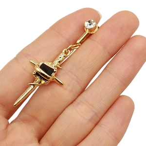 Detailed view of golden belly ring featuring a black rectangular stone and clear zircon