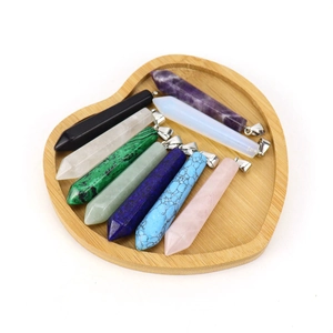 Close-up of colorful hexagonal crystal pendants in a heart-shaped wooden tray
