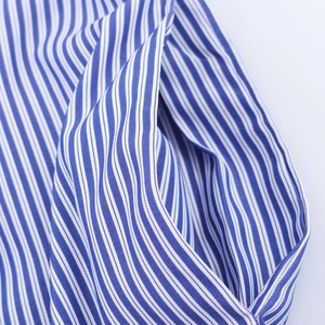 Gros plan sur les coutures de qualité d'un tissu tissé en coton rayé bleu et blanc