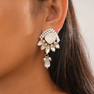 Detailed macro view of diamond resin pearl earrings with geometric teardrop drop pendants