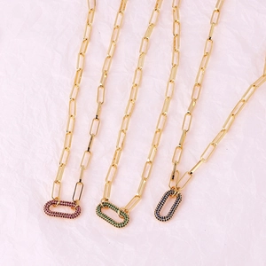 Detailed shot of gold plated paperclip necklaces featuring colored gemstone pendants