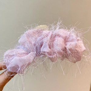 Détail de la pince à cheveux en acrylique avec plumes synthétiques rose violet clair