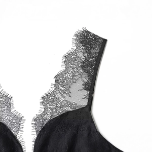 Sexy zwarte kanten top met fijne wimperrand en mesh-textuur op een witte achtergrond