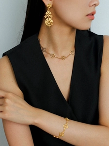Detail of vintage hollow flower tassel earrings and matching jewelry set on a model