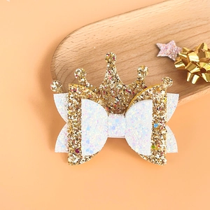 Detail shot of multi-layered glitter gold crown and white bow princess hair clip
