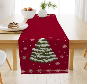 Detailed view of a red linen Christmas table runner with snow-covered tree and snowflakes