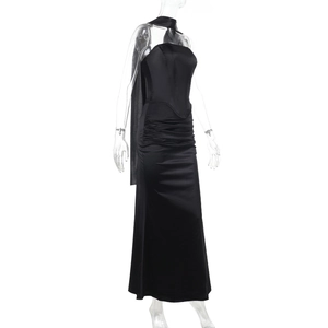 Dettaglio dell'abito a fascia in raso nero con pieghe in vita e accessorio decorativo da collo