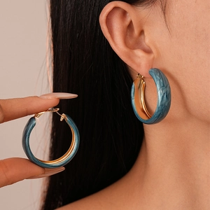 Detail view of vintage blue marble enamel wide hoop earrings with gold inner lining