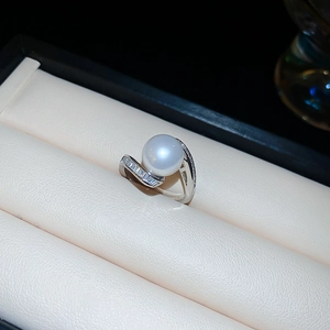 Gros plan d'une bague serpent en argent avec perle blanche et zircons baguettes sertis